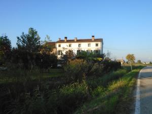 una casa blanca a un lado de la carretera en Agriturismo Loghino Sabbioni, en Suzzara