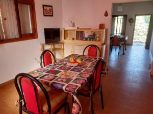 a dining room table with red chairs and a tablecloth on it at Vallesito in Salsipuedes +8 photos