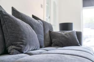 a row of pillows on a couch in a living room at Large 5 Bedroom House Perfect For Group Stays - Free Parking - Near Glasgow - Perfect For Contractors in High Blantyre +10 photos