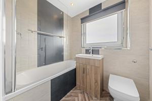 a bathroom with a toilet and a tub and a sink at Large 5 Bedroom House Perfect For Group Stays - Free Parking - Near Glasgow - Perfect For Contractors in High Blantyre