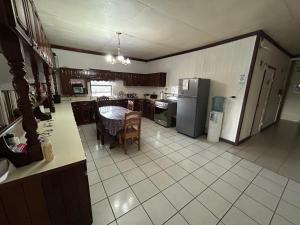 a large kitchen with a table and a refrigerator at Don Santiago Guesthouse Downtown in San Ignacio