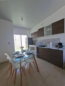a kitchen with a table and chairs in a kitchen at Candy House Marsella in Sitio Grande +4 photos