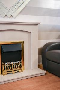 a living room with a fireplace with a black couch at Jake's House in Airdrie