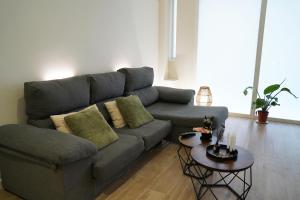 a living room with a gray couch and a table at Casa Dolce Casa - Elegant 3BR Apartment Near Metro & Beach,Valencia in Valencia