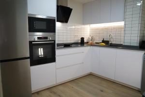 a kitchen with white cabinets and a stove top oven at Casa Dolce Casa - Elegant 3BR Apartment Near Metro & Beach,Valencia in Valencia