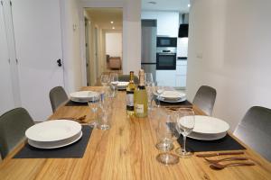 a dining room table with glasses and wine bottles at Casa Dolce Casa - Elegant 3BR Apartment Near Metro & Beach,Valencia in Valencia