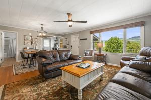 a living room with leather furniture and a table at Mountain View Cottage by Carolina Mornings in Waynesville