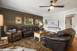 a living room with leather furniture and a ceiling fan at Mountain View Cottage by Carolina Mornings in Waynesville
