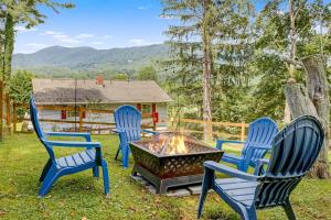 a group of three chairs around a fire pit at Mountain View Cottage by Carolina Mornings in Waynesville
