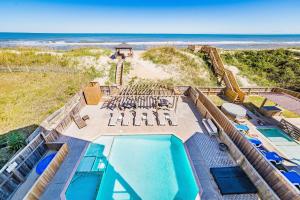 an aerial view of a resort with a swimming pool and the beach at Good Karma Retreat - Nags Head MP 15.5, Oceanfront, Elevator, Pool, Hot Tub, Pets OK, Flex Stays in Nags Head