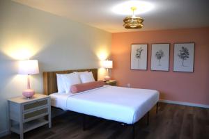a bedroom with a large white bed and two lamps at Inn at the Waterpark in Galveston +30 photos