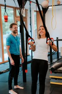 a man and a woman in a gym with ropes at Hotel Der Waldhof in Vollan