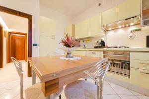a kitchen with a wooden table with chairs and a vase of flowers at Relax Stay vicino Padova e Brenta in Vigonza +20 photos