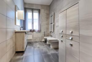 a bathroom with two sinks and a toilet and a window at Relax Stay vicino Padova e Brenta in Vigonza