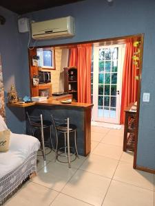 a kitchen with a counter and two bar stools at Sentirse en casa in Puerto Iguazú