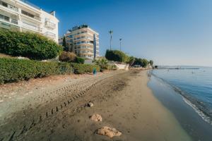 a sandy beach with buildings and the ocean at Beach Front View Apartment Sea Pool & Prime Location in Limassol