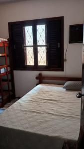 a bedroom with a bed and a window at Bruno Pereira in Guarujá