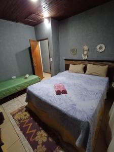 a bedroom with a bed with pink slippers on it at Sentirse en casa in Puerto Iguazú +8 photos