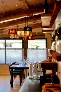 a dining room with a table with chairs and lights at Domaine de Barthas in Castelnau-Magnoac