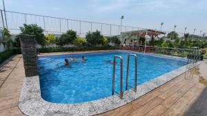 a group of people swimming in a swimming pool at The Prem Royal Resort & Hotel in Dāūd Khān