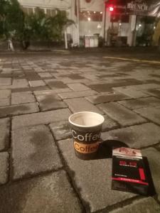 a cup of coffee and a box on a street at Sakinah Rumah Kost in Sanggung