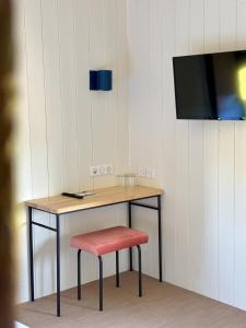 a desk with a chair and a tv on a wall at Domaine de Barthas in Castelnau-Magnoac