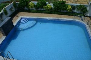a large swimming pool with blue water at The Prem Royal Resort & Hotel in Dāūd Khān +23 photos