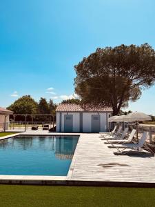 a swimming pool with lounge chairs and a building at Domaine de Barthas in Castelnau-Magnoac