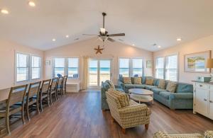 a living room with a couch and a table and chairs at Carolina Sunshine - Nags Head MP 16, Oceanfront, Pool, Hot Tub, Pets OK, Flex Stays in Nags Head