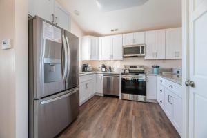 a kitchen with white cabinets and a stainless steel refrigerator at Carolina Sunshine - Nags Head MP 16, Oceanfront, Pool, Hot Tub, Pets OK, Flex Stays in Nags Head +59 photos