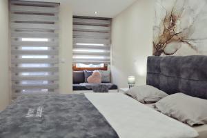 a bedroom with a bed and a couch at Apartman Jaman - Novi Pazar in Novi Pazar