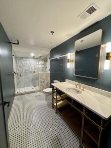 a bathroom with a sink and a toilet and a mirror at The Laurel Hotel in Danville