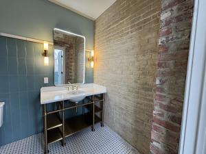 a bathroom with a sink and a brick wall at The Laurel Hotel in Danville +6 photos