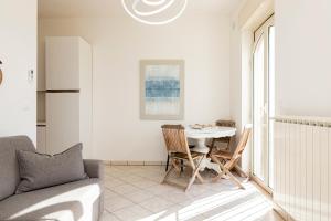 a white living room with a table and chairs at Blue Dreams - Marittima in Marittima +23 photos
