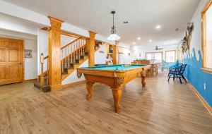 a living room with a pool table and a staircase at Dune Diamond - Nags Head MP 16.5, Oceanfront, Elevator, Heated Pool, Hot Tub, Pets OK, Flex Stays in Nags Head