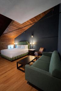 a bedroom with a bed and a couch and a table at The Laurel Hotel in Danville