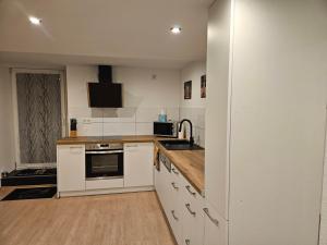a kitchen with white cabinets and a sink at Ferienwohnung Quierschied in Quierschied