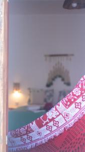 a view of a bedroom with a red and white curtain at Vila Manguita Suíte Manguita in São Gonçalo do Amarante
