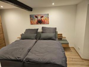 a bed in a room with a painting on the wall at Ferienwohnung Quierschied in Quierschied