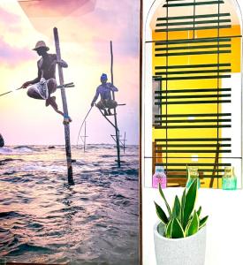 a man on a stand up paddle board in the water at Nishi Villa in Negombo