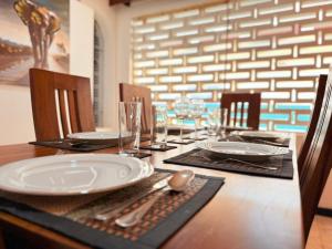 a wooden table with a white plate on top at Nishi Villa in Negombo