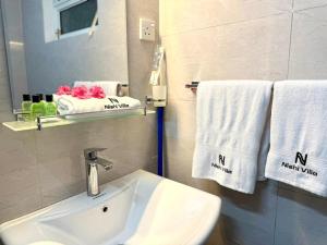 a bathroom with a sink and towels and a mirror at Nishi Villa in Negombo +31 photos