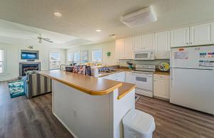 a kitchen with white cabinets and a counter top at Shell Town – Nags Head MP 16, Ocean View, 360 Yds to Beach, Pool, Hot Tub, Flex Stays in Nags Head