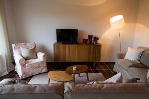uma sala de estar com um sofá e uma televisão em Domizil im Weserbergland em Dölme