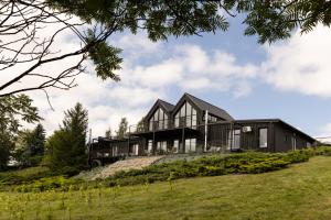 a black house on top of a hill at Port Rybaki & Vine Agritourism in Brodnica
