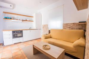 a living room with a yellow couch and a table at GuestReady - Calvario Rota 30 JC in Rota