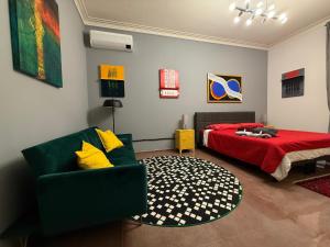 a bedroom with a bed and a green chair at Minardi Apartments in Vercelli