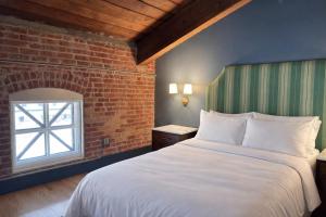 a bedroom with a large bed and a brick wall at The Laurel Hotel in Danville
