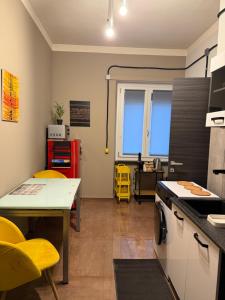a kitchen with a table and yellow chairs in it at Minardi Apartments in Vercelli
