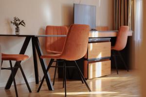 a desk with two orange chairs at a table at Schloss Haus Boutique in Braşov